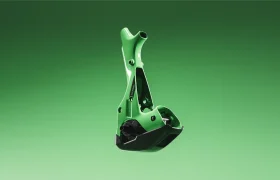 Un componente del cuadro de una bicicleta, de metal verde y negro —que recuerda a la innovadora SCOTT Strike 2027—, aparece suspendido sobre un fondo liso con un degradado verde.