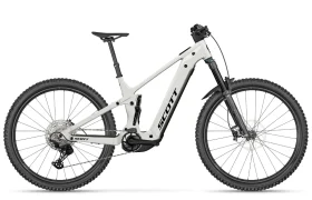 En una vista lateral sobre un fondo liso se muestra una bicicleta de montaña eléctrica SCOTT Strike 2027 de color blanco, con suspensión total, frenos de disco y neumáticos con tacos, equipada con un motor Bosch CX para mayor comodidad.