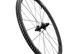 Una sola rueda de bicicleta Zipp 2026 negra con radios, mostrada en ángulo sobre un fondo blanco liso, diseñada para ayudarte a rodar más rápido.